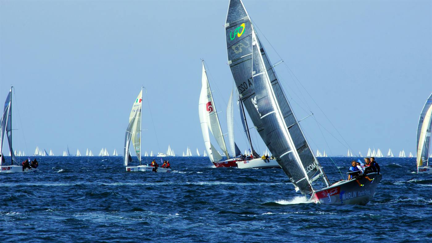 A large fleet on the start line, boats reaching away in both directions.